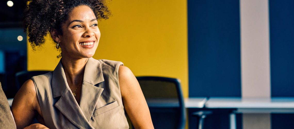 Smiling professional African American woman engaging in a business meeting with a colleague. Creative office setting and team interaction concept